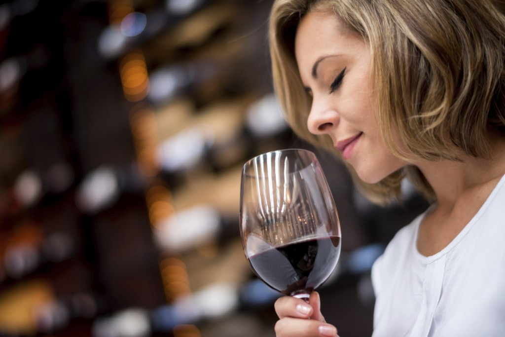 woman exploring nose of glass of red wine